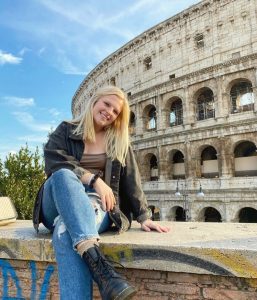 Kylie smiles for the camera. In the background is Rome's colosseum