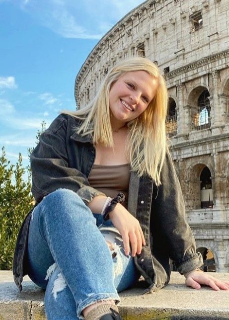 Kylie smiles for the camera. In the background is Rome's colosseum