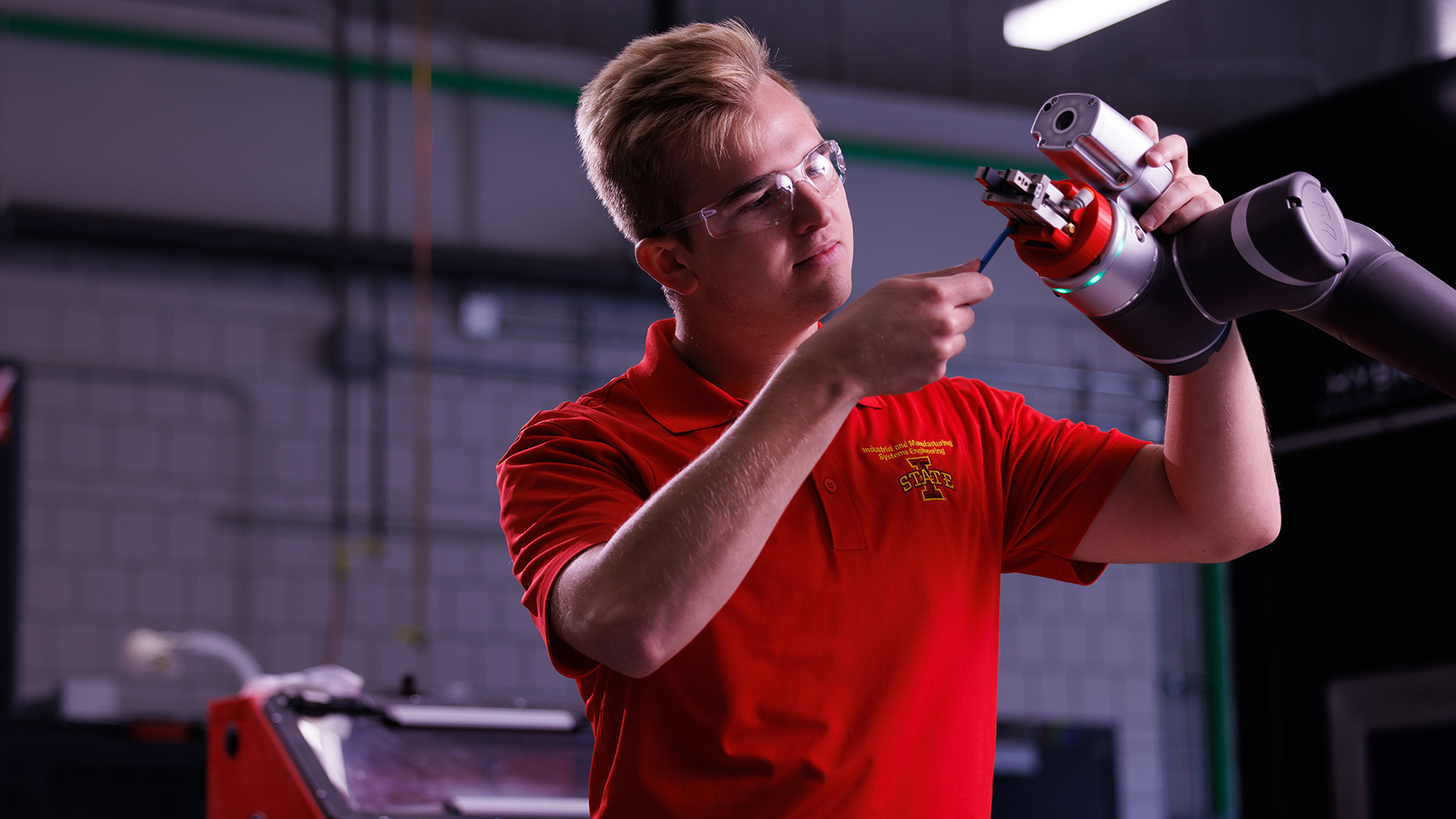 student adjusting robotic arm