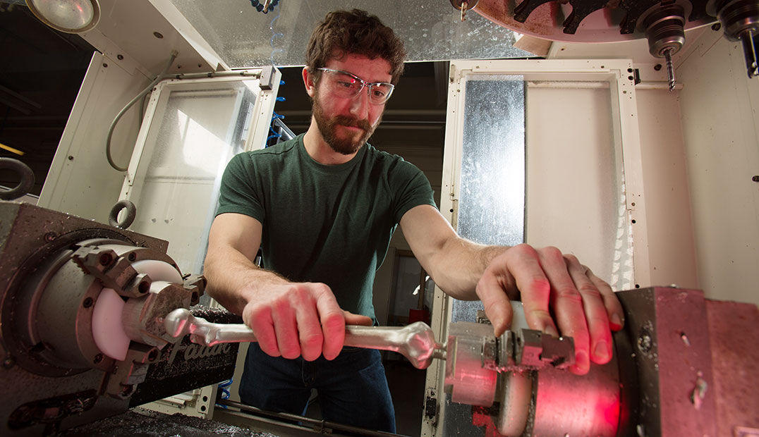 student working with metal lathe