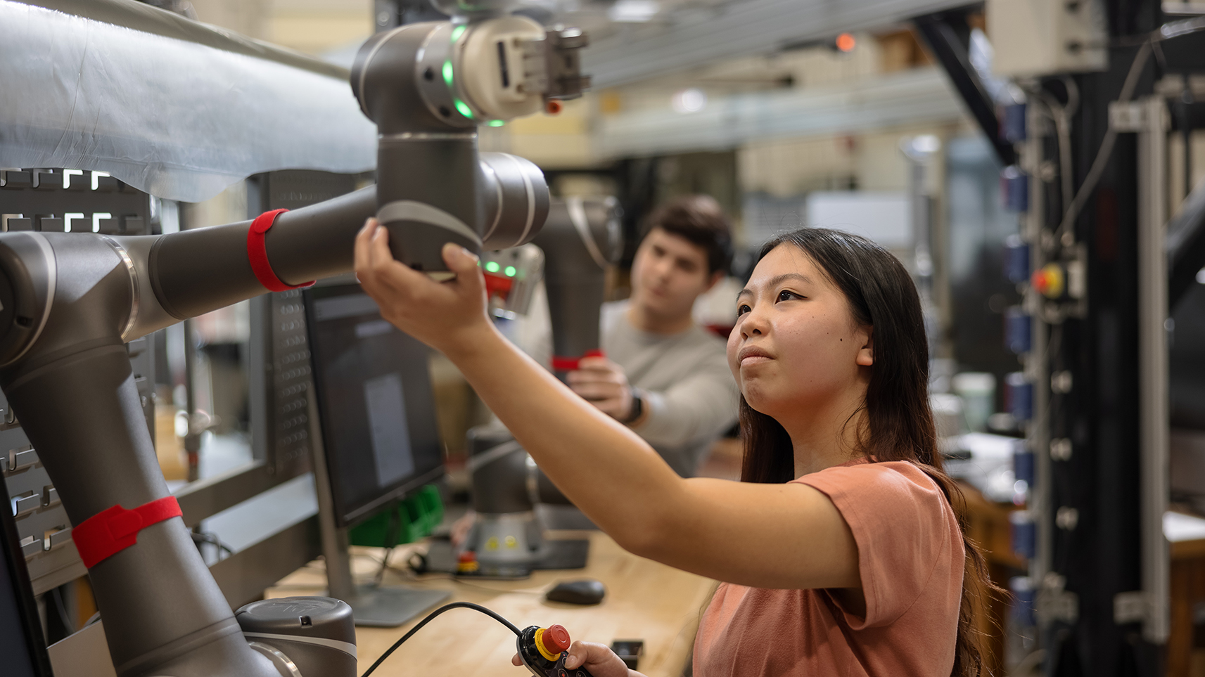 student working with robotic arm in lab